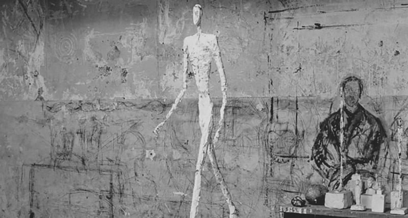 Alberto Giacometti travaillant sur une de ses célèbres sculptures d’homme qui marche dans son atelier parisien